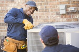 two-techs-standing-over-outside-ac-unit