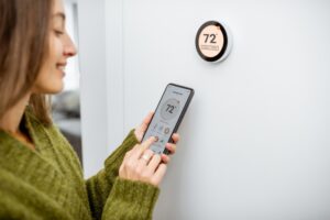 woman-adjusts-thermostat-with-app-on-smartphone